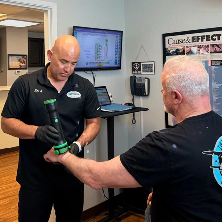 Dr. Aranibar using a tool to adjust a patient's wrist