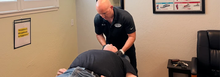 A patient lying on their back while their neck is adjusted