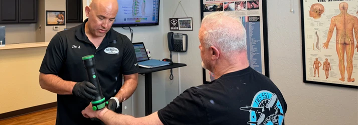 Jorge Aranibar using a tool to adjust a patient's wrist for carpal tunnel