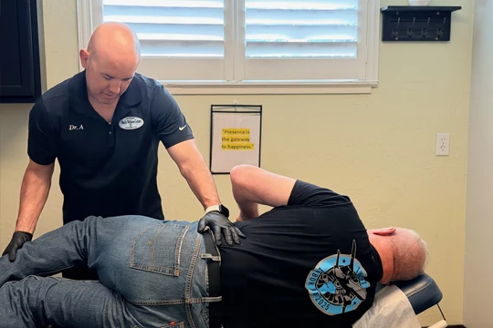 A patient on their side during an adjustment, being adjusted by Dr. Aranibar