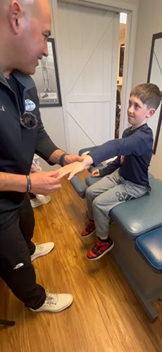 Dr. Aranibar adjusting a pediatric patient's arm